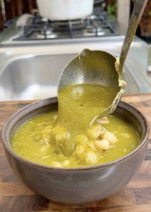 Ladling pozole into serving bowls.