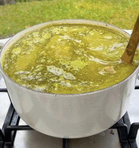 Pot of pozole verde simmering with chicken and hominy.