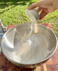 Sugar, baking powder, and salt added to flour for buñuelos batter.