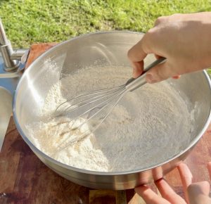 Whisking flour, sugar, baking powder, and salt in a mixing bowl.