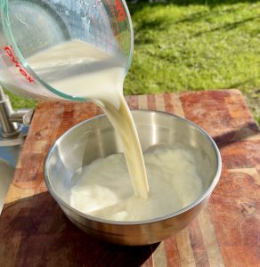 Milk being poured into a clean bowl to start the wet mixture.